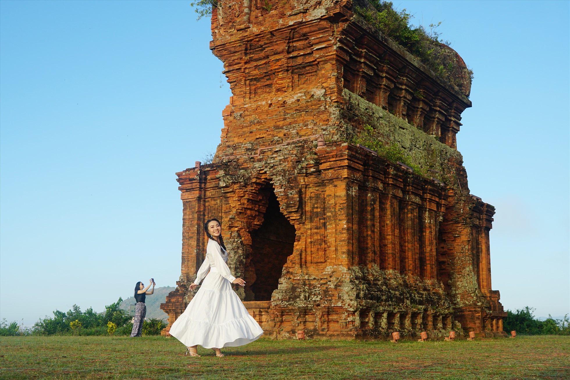 Du khách chụp hình kỉ niệm tại tháp Bánh Ít. Ảnh: Thanh Chân